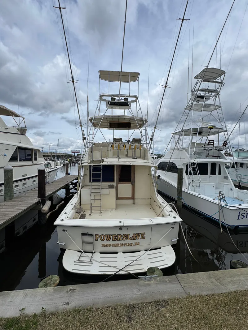Slide: The Image of 1984 Hatteras 46 Convertible yacht docked at marina under cloudy skies. - 24