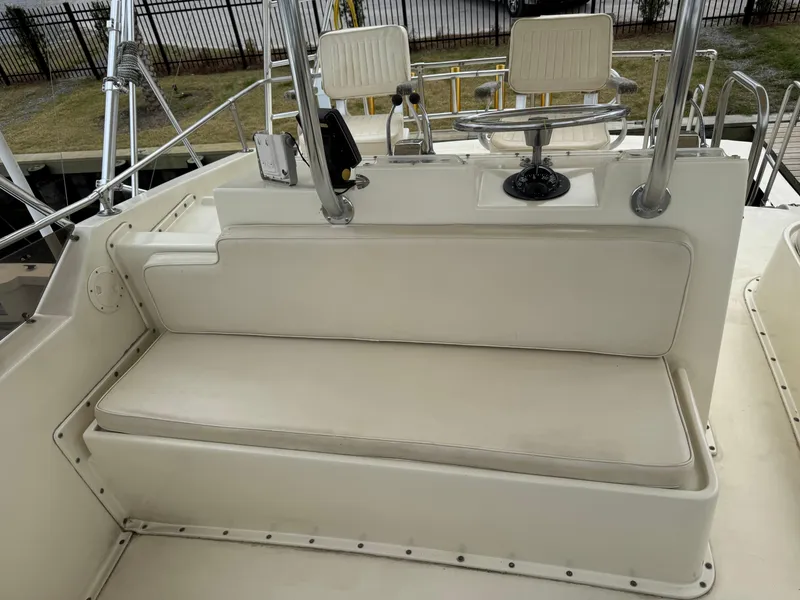 Slide: The Image of 1984 Hatteras 46 Convertible boat seating area with white cushions and helm chairs. - 3