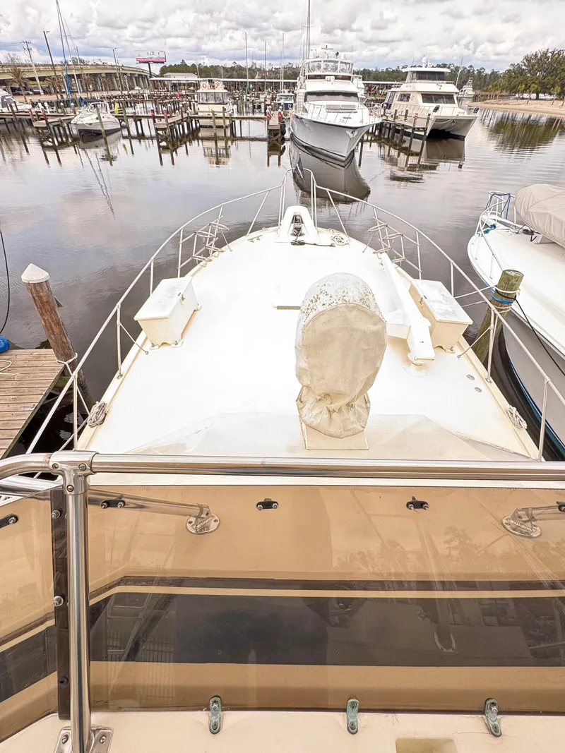 Slide: The Image of 1984 Hatteras 46 Convertible yacht docked at a marina, view from the deck. - 7