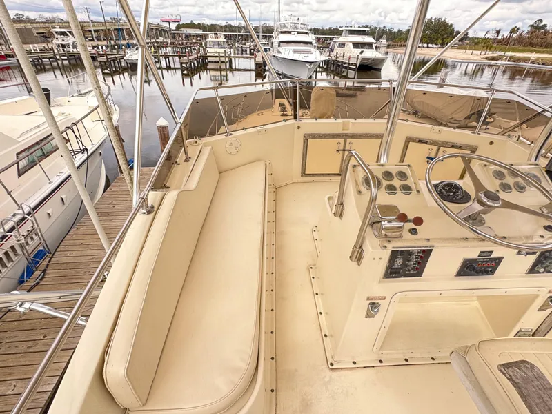 Slide: The Image of 1984 Hatteras 46 Convertible yacht interior with helm and seating at marina. - 8