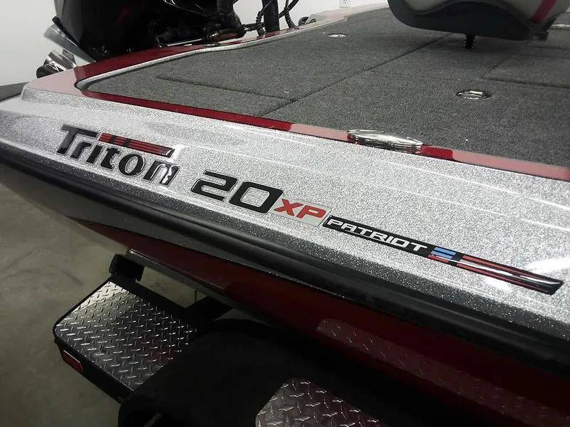 Slide: The Image of 2025 Triton 20XP Patriot boat, sleek design with metallic finish. - 1