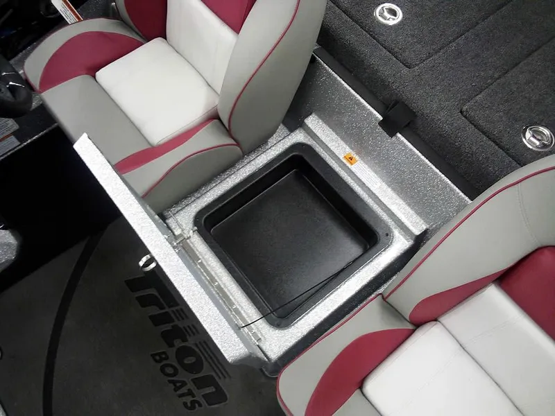 Slide: The Image of 2025 Triton 20XP Patriot boat interior with storage compartment between seats. - 22