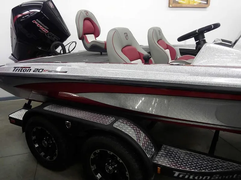Slide: The Image of 2025 Triton 20XP Patriot boat with red and gray seating on a trailer. - 31