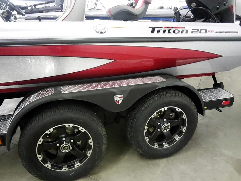 Slide: The Image of 2025 Triton 20XP Patriot boat trailer with dual wheels and sleek red design. - 4