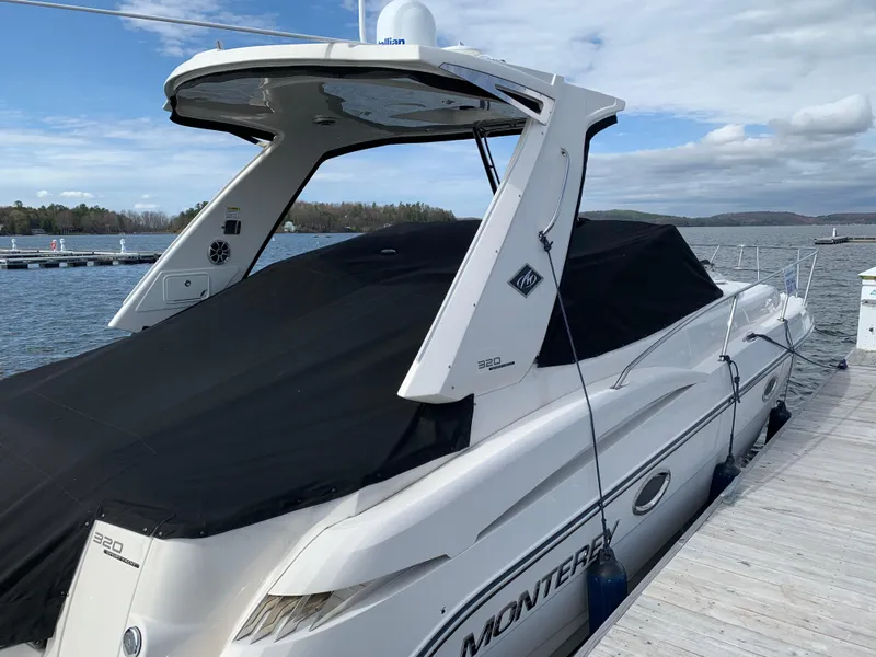 Slide: The Image of 2014 Monterey 320 Sport Yacht docked, covered, with scenic lake background. - 12