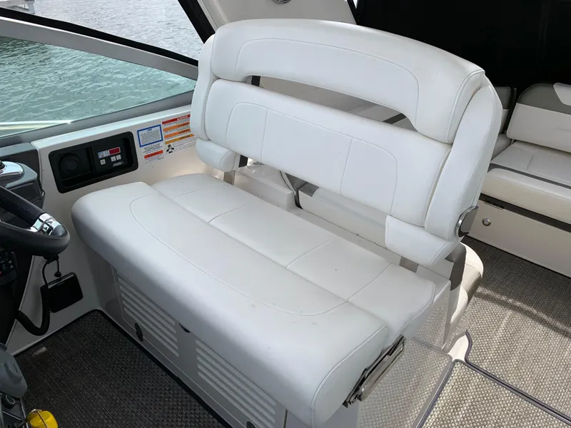 Slide: The Image of White leather seating on 2014 Monterey 320 Sport Yacht, helm area with controls visible. - 25
