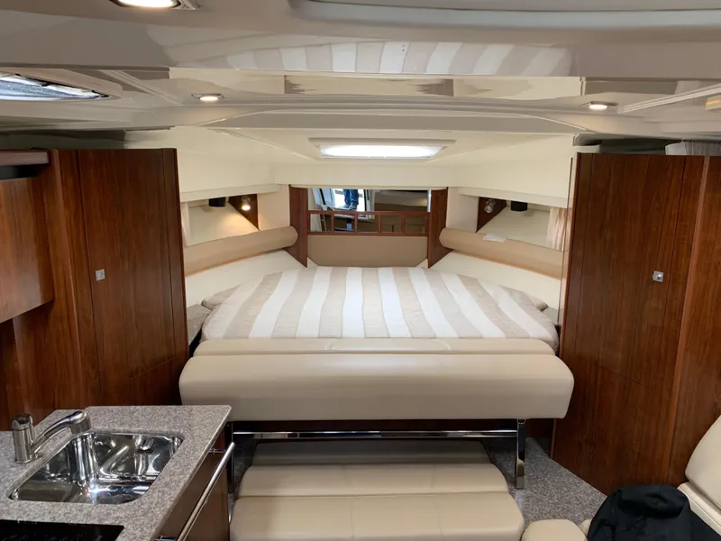 Slide: The Image of Interior of 2014 Monterey 320 Sport Yacht with modern wood finish and cozy sleeping area. - 31