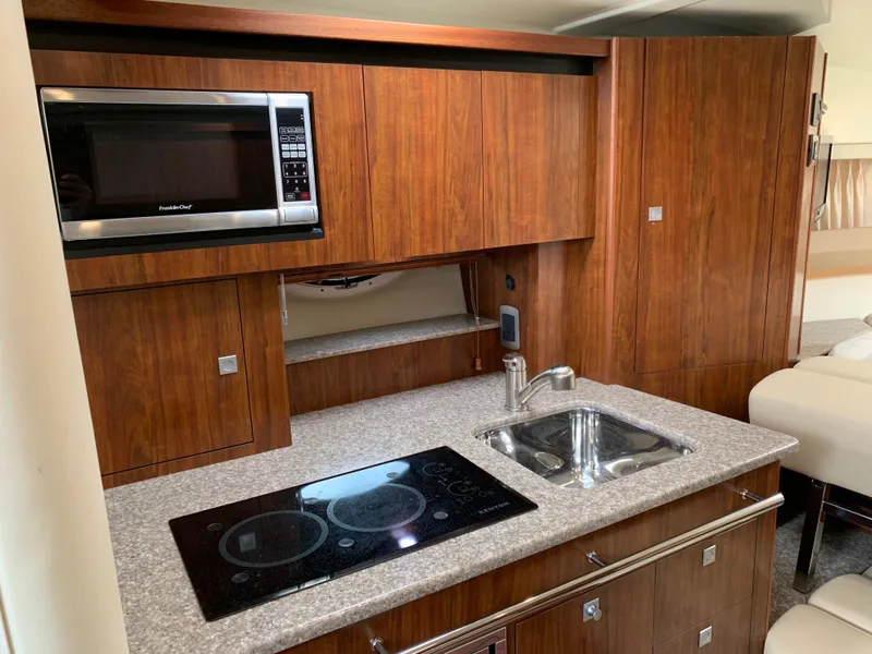 Slide: The Image of 2014 Monterey 320 Sport Yacht kitchen with microwave, stove, and sink. - 32