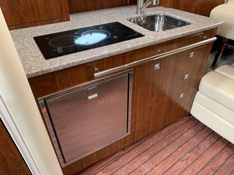 Slide: The Image of 2014 Monterey 320 Sport Yacht kitchen with stove, sink, and wood cabinetry. - 33