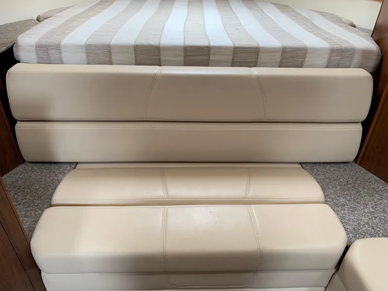 Slide: The Image of Interior of 2014 Monterey 320 Sport Yacht with beige cushioned steps and striped bedding. - 35