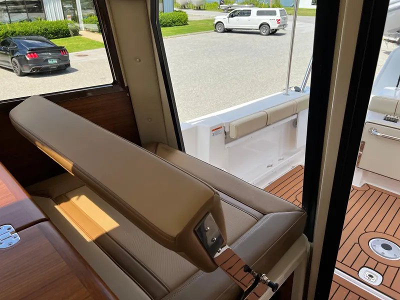 Slide: The Image of 2024 Ranger Tugs R-27 interior with tan seating and wooden flooring. - 14