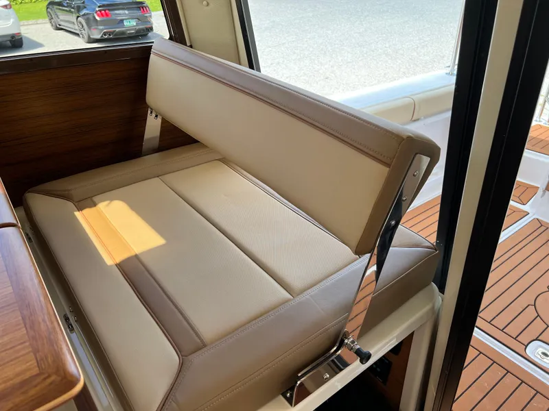 Slide: The Image of 2024 Ranger Tugs R-27 interior seating with beige upholstery and wooden accents. - 15