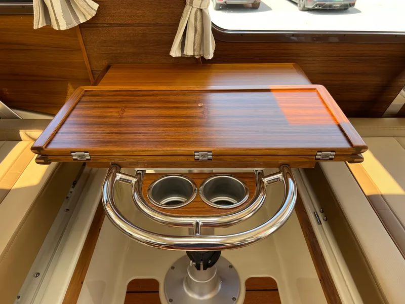 Slide: The Image of 2024 Ranger Tugs R-27 interior with wooden table and cup holders. - 19