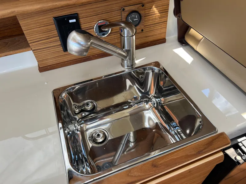 Slide: The Image of Stainless steel sink in 2024 Ranger Tugs R-27 boat interior, featuring modern faucet design. - 21