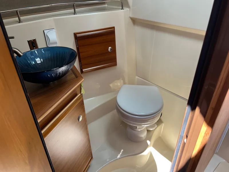 Slide: The Image of 2024 Ranger Tugs R-27 bathroom with modern sink and wooden cabinetry. - 30