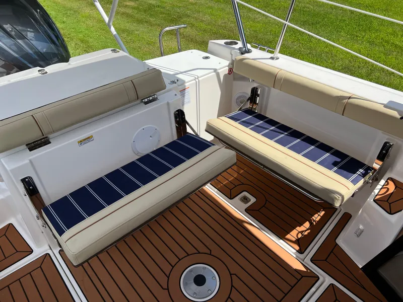 Slide: The Image of 2024 Ranger Tugs R-27 boat interior with foldable seats and teak flooring. - 7