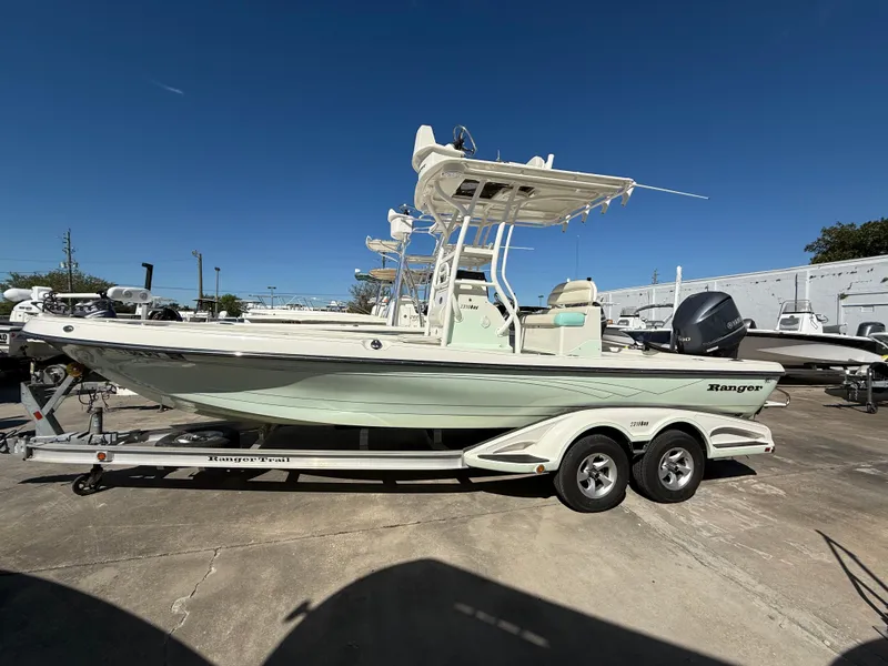 Slide: The Image of 2014 Ranger 2310 Bay boat on trailer under clear blue sky. - 1