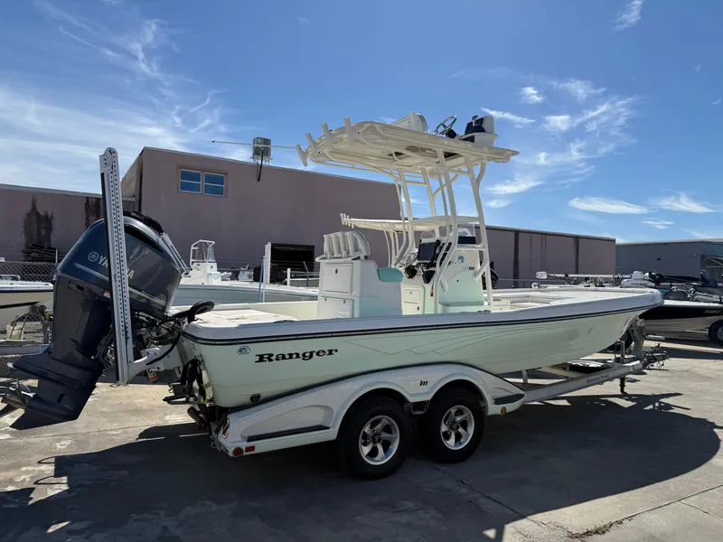 Slide: The Image of 2014 Ranger 2310 Bay boat on trailer, parked outdoors under clear sky. - 12