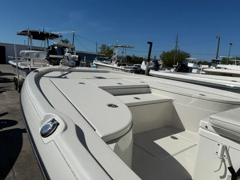 Slide: The Image of 2014 Ranger 2310 Bay boat, white interior, docked under clear blue sky. - 4