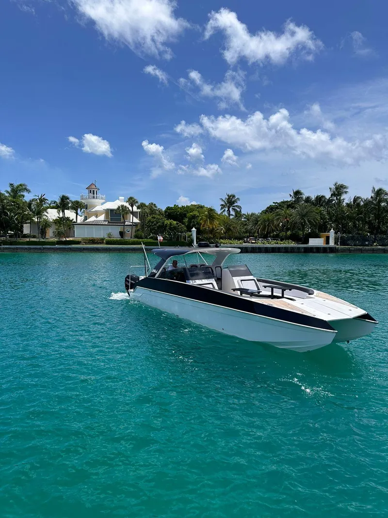 Slide: The Image of 2022 Catamaran PRJ Cat40 cruising on turquoise water near a tropical shoreline. - 19