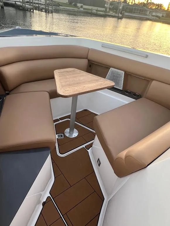 Slide: The Image of 2023 Aviara AV32 OB boat interior with tan seating and wooden table by the water. - 17