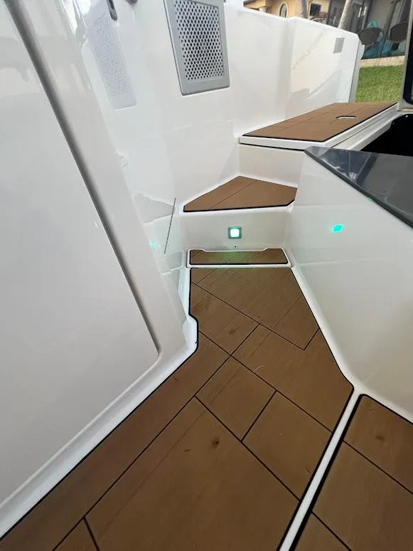 Slide: The Image of 2023 Aviara AV32 OB boat interior with sleek wooden flooring and illuminated steps. - 19