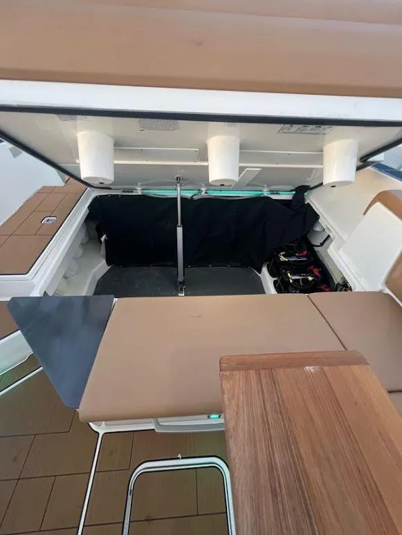 Slide: The Image of 2023 Aviara AV32 OB boat interior storage compartment with open hatch and seating area. - 20