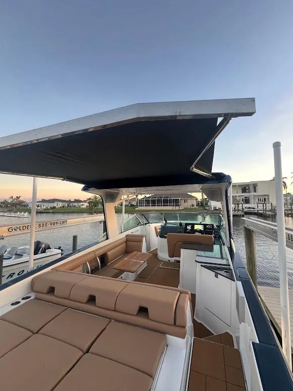 Slide: The Image of 2023 Aviara AV32 OB boat with spacious seating and canopy, docked by the waterfront. - 4