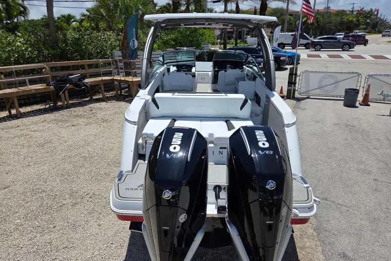 Slide: The Image of 2025 Four Winns H9 OB boat with dual outboard engines, parked outdoors. - 22