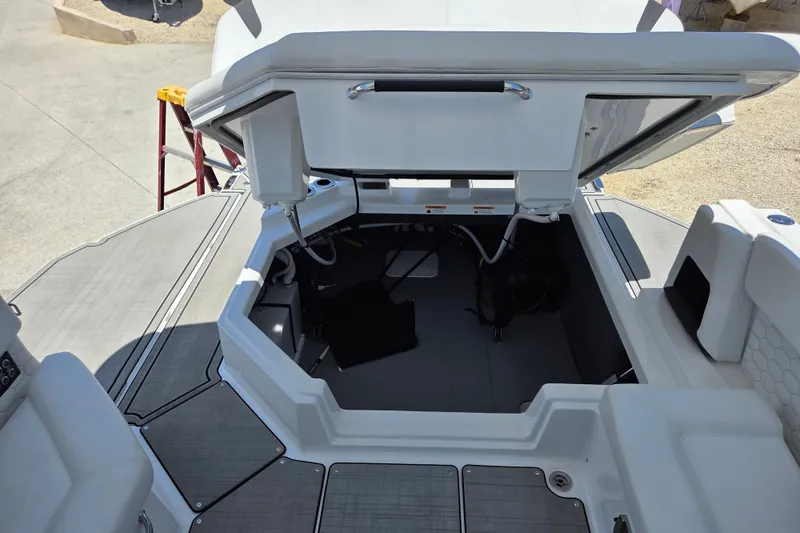 Slide: The Image of 2025 Four Winns H9 OB boat storage compartment with open hatch, showcasing interior space. - 11