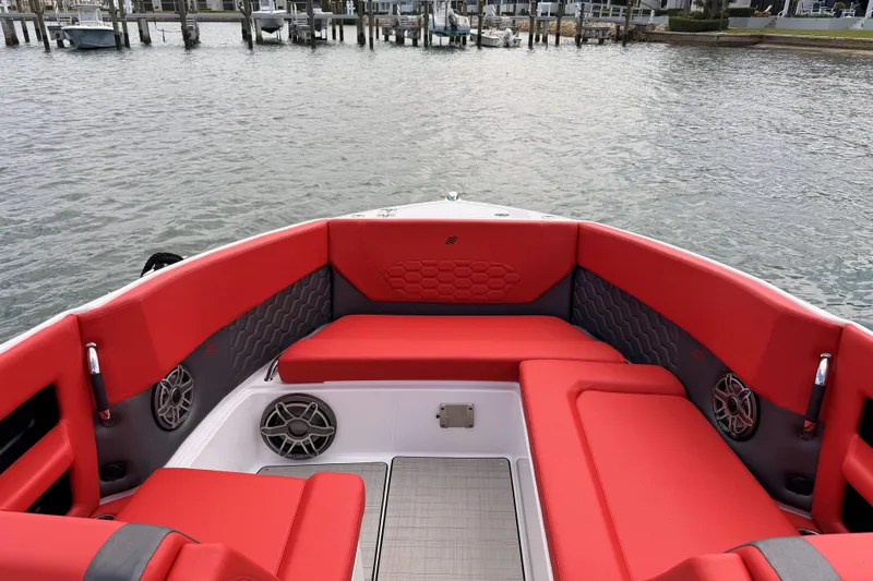 Slide: The Image of 2025 Four Winns H9 OB boat with red seating, docked by the water. - 10