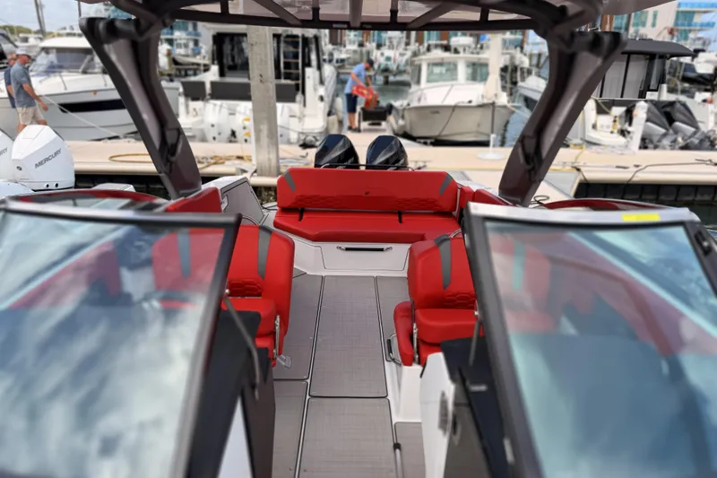 Slide: The Image of 2025 Four Winns H9 OB boat with red seating at a marina. - 11