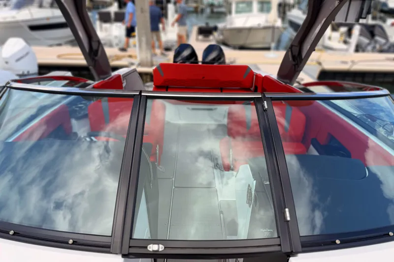 Slide: The Image of 2025 Four Winns H9 OB boat with red interior, docked at marina. - 12