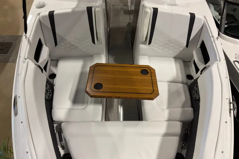 Slide: The Image of 2025 Four Winns H9 OB boat interior with white seating and wooden table. - 17