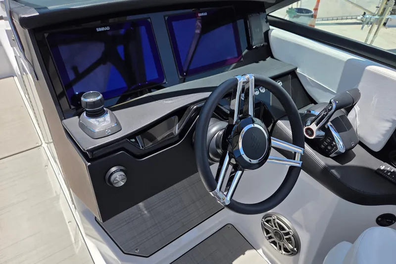Slide: The Image of 2025 Four Winns H9 OB boat dashboard with modern steering wheel and controls. - 3