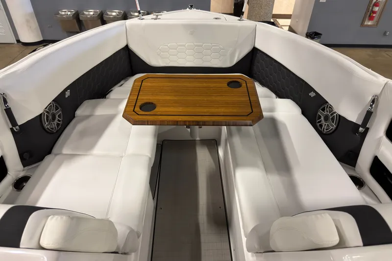 Slide: The Image of 2025 Four Winns H9 OB boat interior with white seating and wooden table. - 16