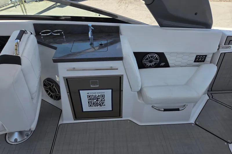 Slide: The Image of 2025 Four Winns H9 OB boat interior with sink, seating, and QR code panel. - 7