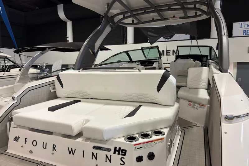 Slide: The Image of 2025 Four Winns H9 OB luxury boat interior with white seating and modern design. - 2