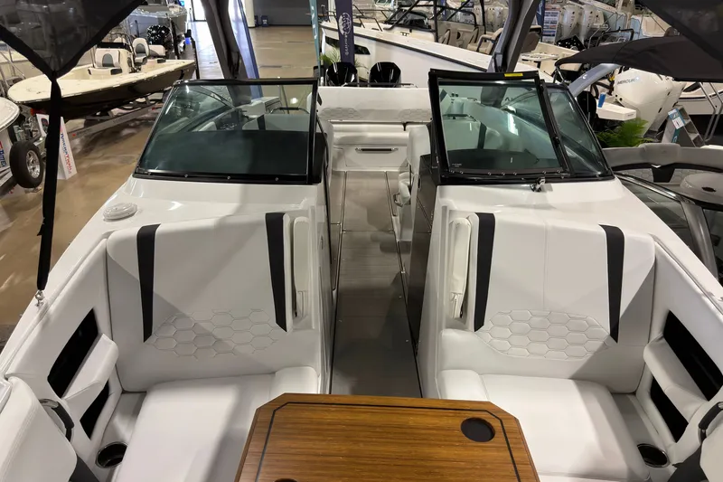 Slide: The Image of 2025 Four Winns H9 OB boat interior with white seating and wooden table. - 18