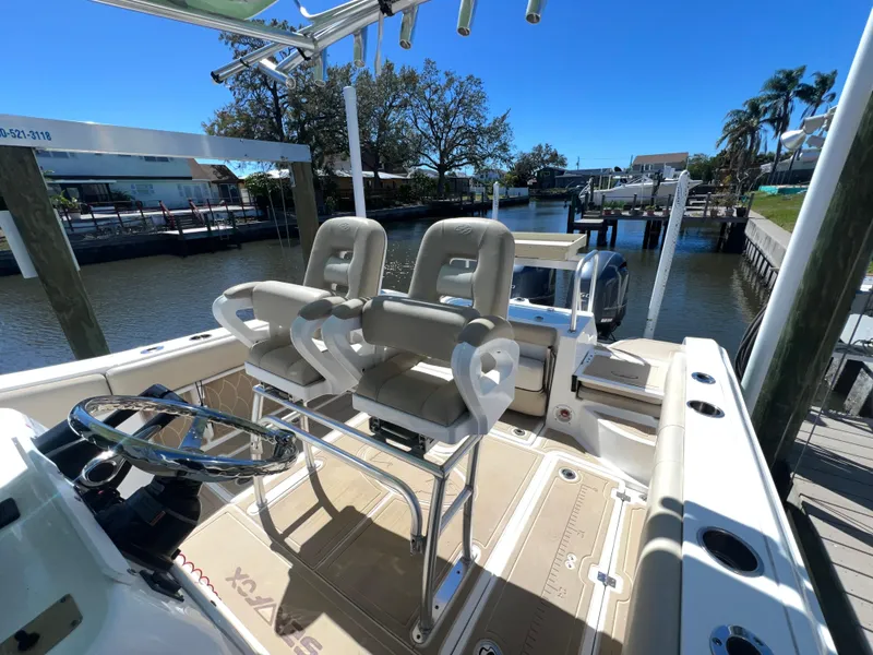 Slide: The Image of 2016 Sea Fox 266 Commander boat with dual seats, docked by a serene waterfront. - 11