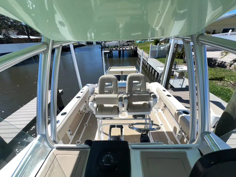Slide: The Image of 2016 Sea Fox 266 Commander boat interior with dual seats, docked by a serene waterway. - 12