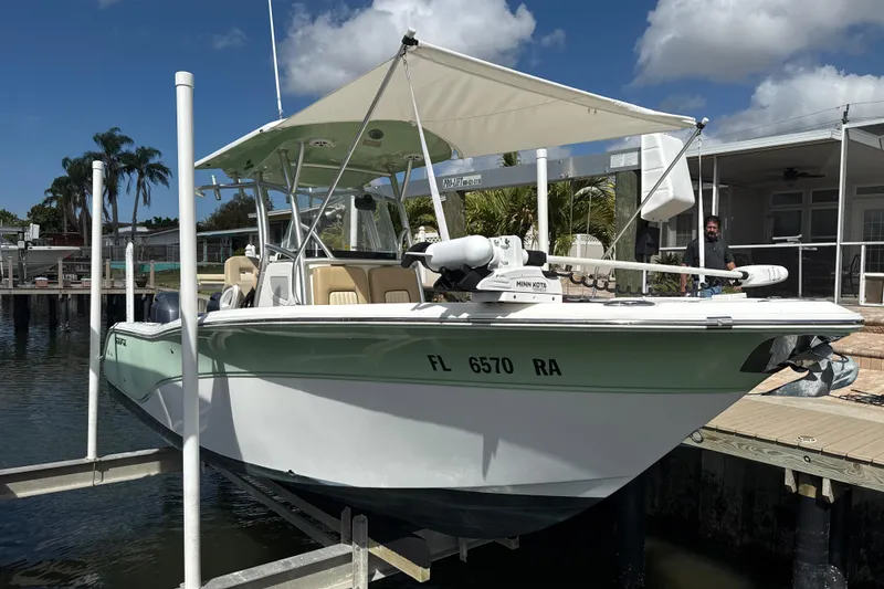 Slide: The Image of 2016 Sea Fox 266 Commander boat docked, featuring a canopy and Minn Kota trolling motor. - 2