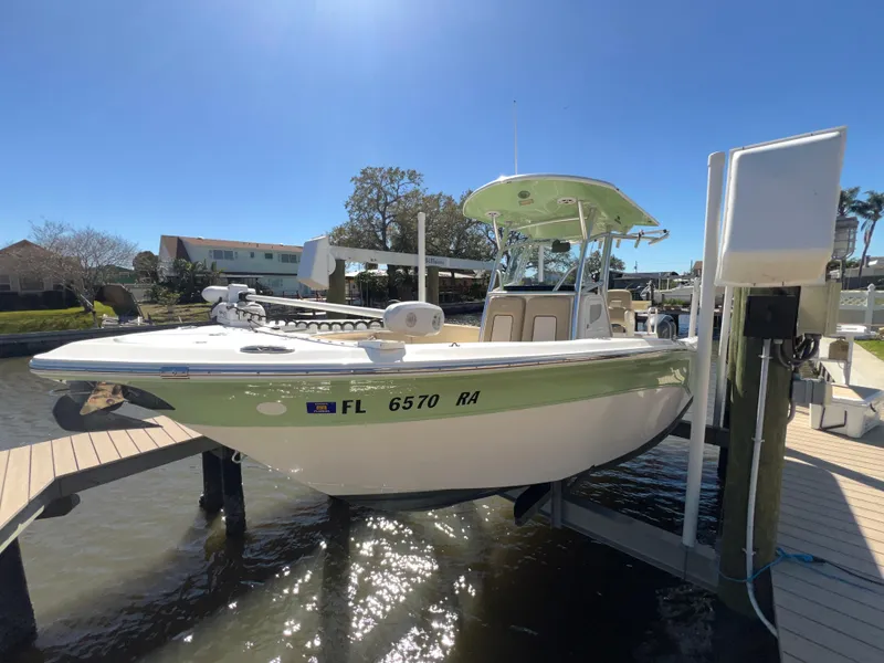 Slide: The Image of 2016 Sea Fox 266 Commander boat docked on a lift under clear blue skies. - 37
