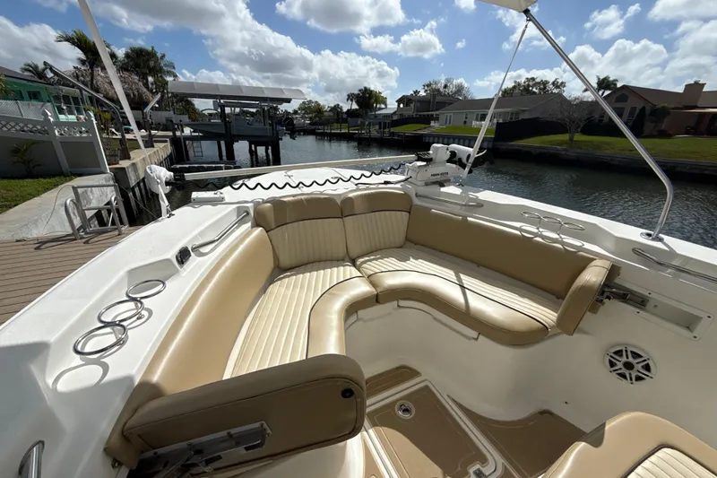 Slide: The Image of 2016 Sea Fox 266 Commander boat with spacious seating and cup holders, docked by a canal. - 41