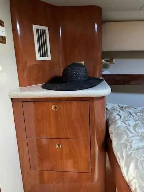 Slide: The Image of 2006 Fountain 38 Express Cruiser cabin with wooden cabinetry and a black hat on the counter. - 13