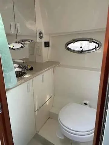 Slide: The Image of 2006 Fountain 38 Express Cruiser bathroom with sink, toilet, and storage cabinets. - 14