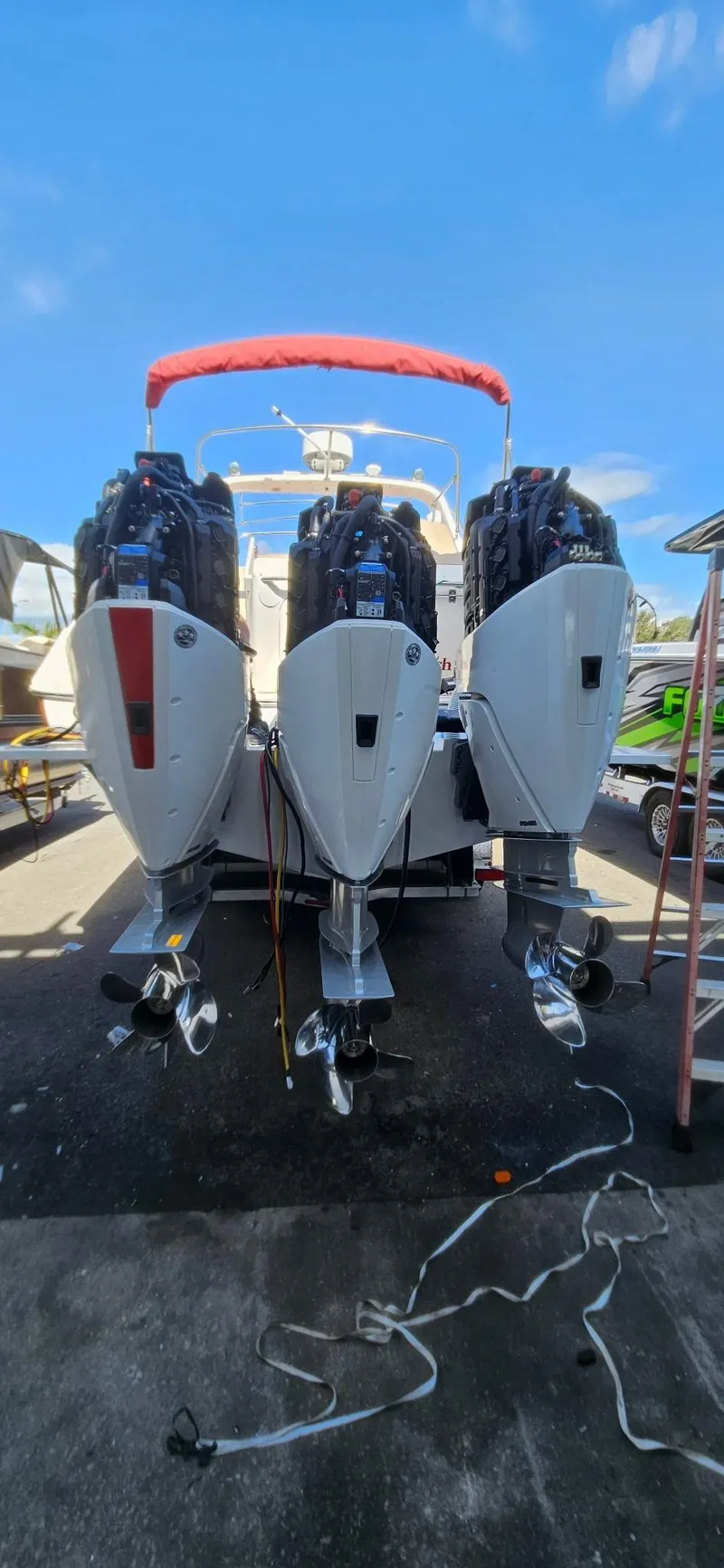 Slide: The Image of 2006 Fountain 38 Express Cruiser with triple outboard engines, docked under a clear blue sky. - 21