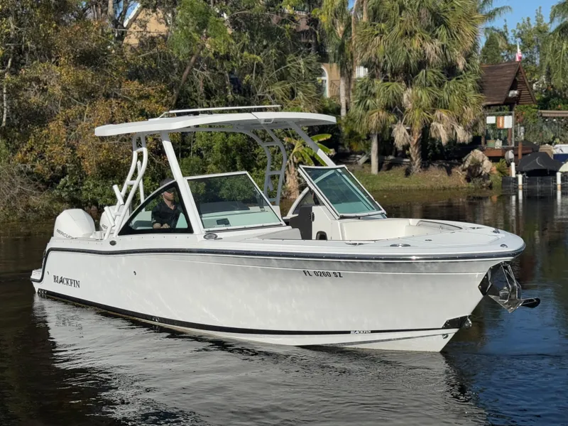 Slide: The Image of 2021 Blackfin 252DC boat cruising on a calm river, surrounded by lush greenery. - 12