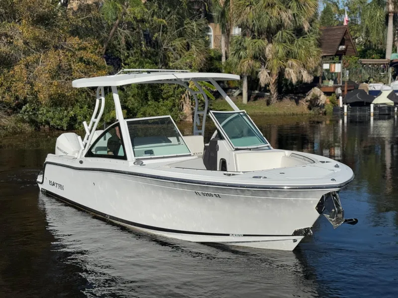 Slide: The Image of 2021 Blackfin 252DC boat on calm water, surrounded by lush greenery. - 13