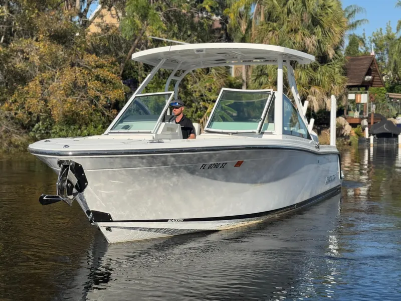 Slide: The Image of 2021 Blackfin 252DC boat cruising on a calm river with lush greenery. - 17